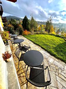 eine Reihe von Tischen und Stühlen auf einer Terrasse in der Unterkunft Penzion Zrzka in Kořenov