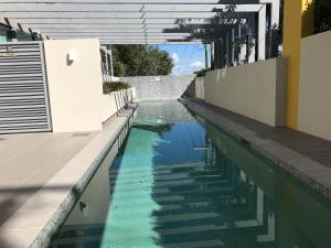 a swimming pool on the side of a house at Nova Apartment Mooloolaba Beach in Mooloolaba