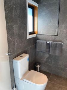 uma casa de banho com um WC branco e um espelho. em Anchor Wheel Motel em St Helens