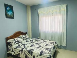 a bedroom with a bed and a window at Mi Gran Victoria in Manta