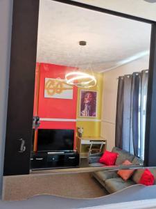 a reflection of a living room with a couch and a tv at The Superhost - 4 BR House in Sunderland