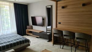 um quarto com uma cama, uma secretária e um espelho em Woodside apartments Kopaonik em Kopaonik