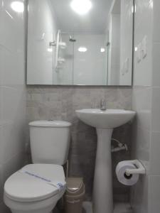 a bathroom with a toilet and a sink and a mirror at Casa Jac in Bucaramanga