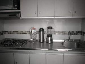 a kitchen counter with a sink and a stove top at Casa Jac in Bucaramanga