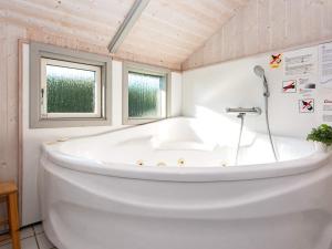 a white tub in a bathroom with a window at 6 person holiday home in R nde in Rønde