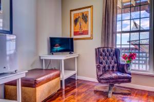 a room with a desk and a chair and a computer at Lands End in West End