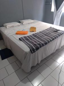 a bed with a black and white blanket on it at Apartamento no Centro de Blumenau in Blumenau