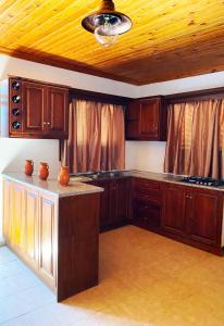 a kitchen with wooden cabinets and a ceiling at Tetrapolis cottage in Karpathos +6 photos
