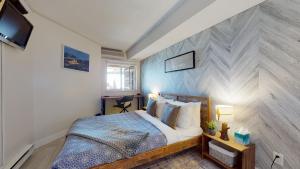 a bedroom with a large bed with a wooden headboard at 1BR plus Den Village Condo with Mountain Views and Hot Tub by Harmony Whistler in Whistler