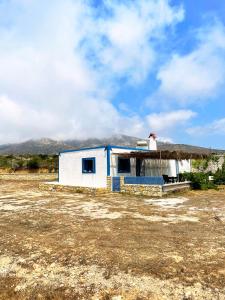 ein kleines weißes Gebäude mit einem Dach auf einem Feld in der Unterkunft Tetrapolis cottage in Karpathos