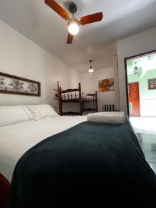 a bedroom with a large bed with a ceiling fan at Porto Abraão Pousada in Abraão