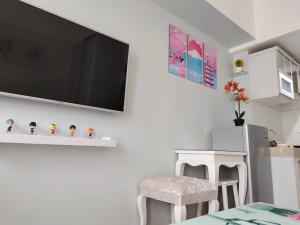 a living room with a tv on a wall at Vasanta Innopark Appartemen in Jarakasta