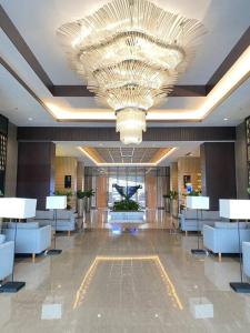 a large lobby with a large chandelier in a building at Vasanta Innopark Appartemen in Jarakasta +10 photos
