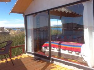 a room with a balcony with a bed on a deck at Uros Titicaca Khantaniwa Lodge in Puno
