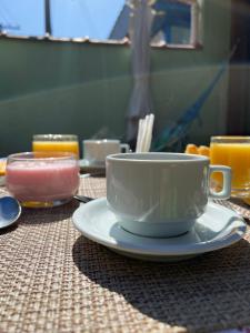 a coffee cup on a plate on a table at Porto Abraão Pousada in Abraão