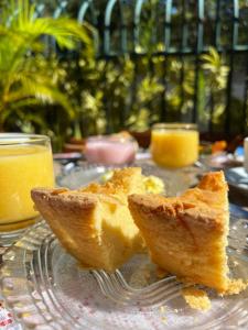 two pieces of bread on a glass plate with orange juice at Porto Abraão Pousada in Abraão