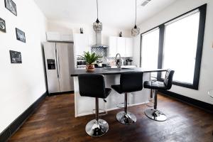 a kitchen with a black counter and two bar stools at Cozy & Stylish Home in Downtown Atlanta in Atlanta