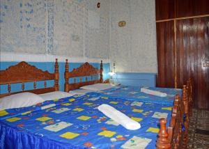 a bedroom with a bed with a blue comforter at Hostal del Pino Appartement 1 in Trinidad