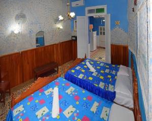 a bedroom with a bed with a blue comforter at Hostal del Pino Appartement 1 in Trinidad