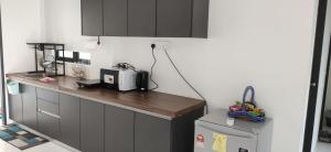 a kitchen with a counter with a microwave and a refrigerator at Professional HomeStay D' Alor Setar in Alor Setar