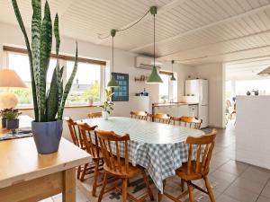Holiday home Ebberup VII في Ebberup: مطبخ وغرفة طعام مع طاولة ونبات الفخار