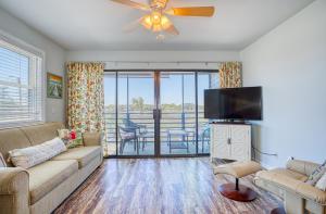 a living room with a couch and a flat screen tv at Bella Vista: Marshfront Condo 1 Block To The Beach. Pool & Hot Tub-1st Floor in Murrells Inlet