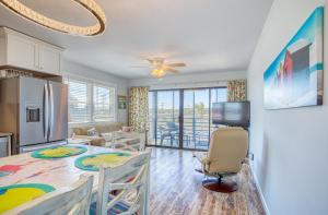 a kitchen and living room with a table and chairs at Bella Vista: Marshfront Condo 1 Block To The Beach. Pool & Hot Tub-1st Floor in Murrells Inlet