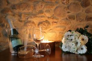un tavolo con una candela e un bicchiere di vino e fiori di Bed & Breakfast Le Coste a Lazise