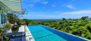 een zwembad in een villa met de oceaan op de achtergrond bij H616 Vintage Elegance with sea view in Kubutambahan