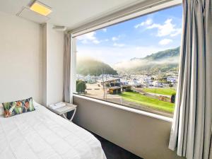 a bedroom with a large window with a view of a city at Oxley's Superior Apartment in Picton