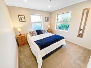 um quarto com uma cama e duas janelas em Oxley's Superior Apartment em Picton