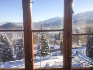 otwarte okno z widokiem na pokryte śniegiem pole w obiekcie Zielone Wzgórze w mieście Karpacz
