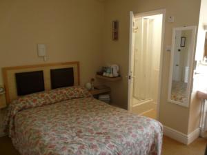 a bedroom with a bed and a door to a bathroom at Melbourne Guest House in Rhyl
