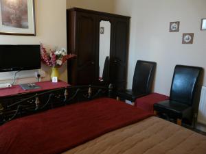 a bedroom with a bed and two chairs and a desk at Melbourne Guest House in Rhyl