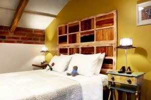 a teddy bear sitting on a bed in a room at Old Town Quito Suites, Heritage Boutique Hotel, Where Every Detail Tells a Story in Quito