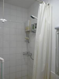 a bathroom with a shower with a shower curtain at Melbourne Guest House in Rhyl