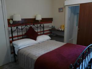 a bedroom with a large bed with a wooden headboard at Melbourne Guest House in Rhyl