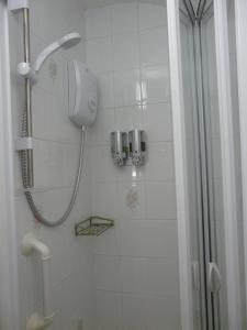 a shower with a shower head in a bathroom at Melbourne Guest House in Rhyl
