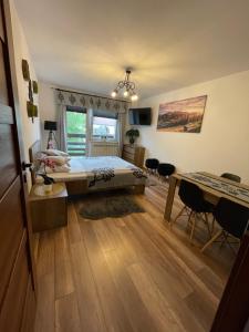 sypialnia z łóżkiem, stołem i krzesłami w obiekcie Apartament Krupówki Centrum w Zakopanem