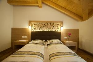 1 dormitorio con 1 cama grande y 2 mesitas de noche en Lüch da Mirió, en La Valle