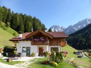 una pequeña casa en una colina con montañas en el fondo en Lüch da Mirió, en La Valle