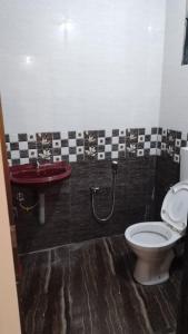 a bathroom with a toilet and a sink at Tendulkar Beach Resort in Diveagar