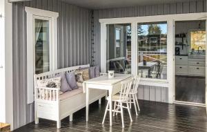 フディクスバルにあるGorgeous Home In Hudiksvall With Wifiのポーチ(テーブル、ベンチ、テーブル、椅子付)