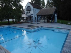 a large swimming pool in front of a house at Le Petit Moulin in Faverelles +35 photos