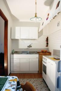 una cocina con armarios blancos y fregadero en Da Rina, en Mestre