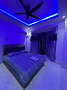 a purple room with a bed with a ceiling fan at D’Alisya Homestay in Tawau