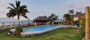 una piscina in un resort vicino all'oceano di Caramba Hospedaje a Tonsupa