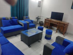 ein Wohnzimmer mit blauen Sofas und einem Klavier in der Unterkunft Amazing Hilltop 4 BHK Villa with Private Pool near Candolim in Candolim