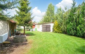 a yard with a garage and a grass field at Stunning Home In Choczewo With 4 Bedrooms in Lubiatowo