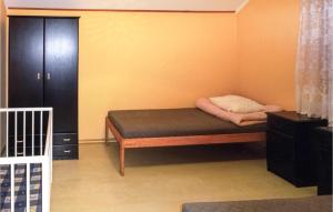 a small bed in a room with a cabinet at Stunning Home In Choczewo With 4 Bedrooms in Lubiatowo